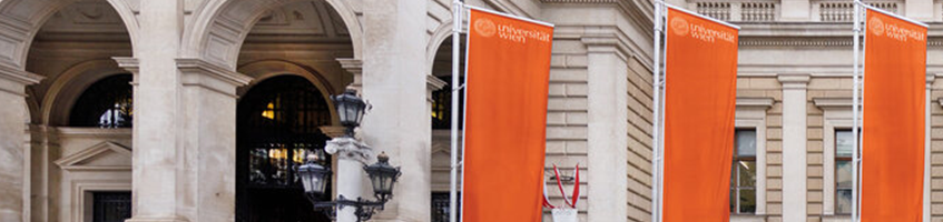 Hauptgebäude der Universität Wien mit drei orangen Flaggen davor